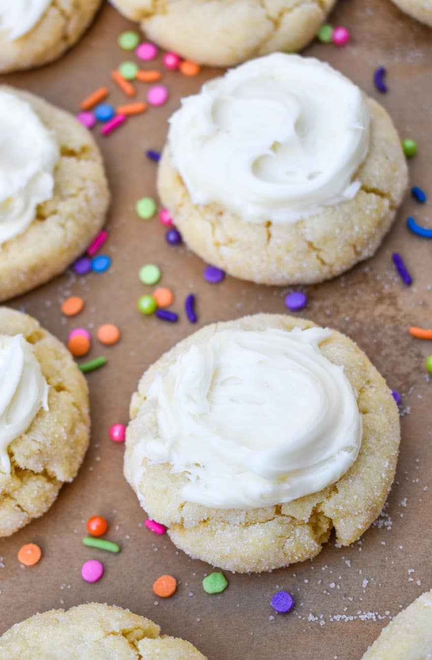 frosted cake mix sugar cookies on a parchment lined baking sheet