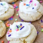 frosted cake mix sugar cookies on a parchment lined baking sheet