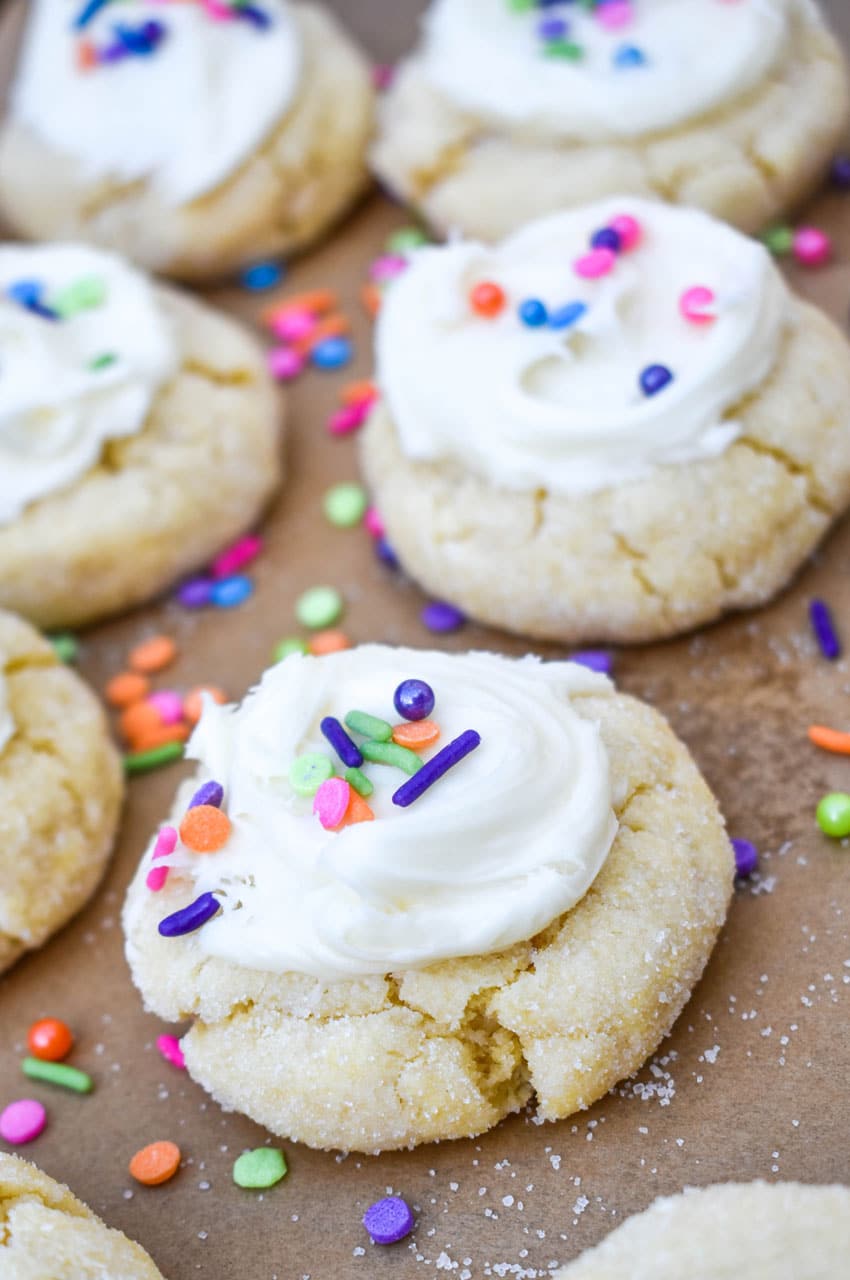 frosted cake mix sugar cookies on a parchment lined baking sheet