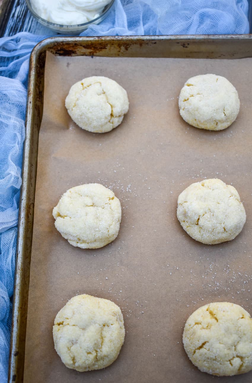 cake mix sugar cookies arranged in rows on a parchment paper lined baking sheet