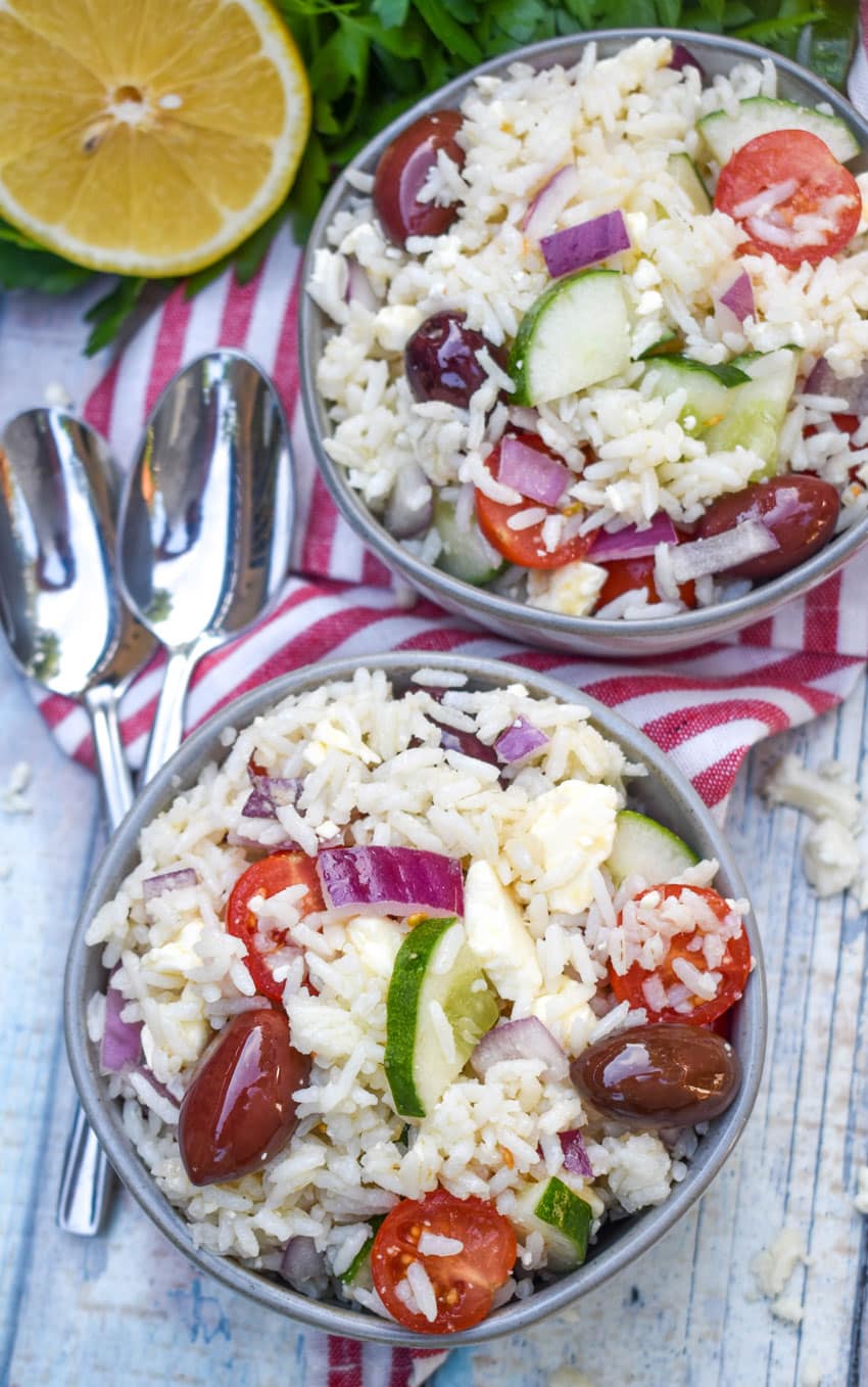 greek rice salad in two small gray bowls