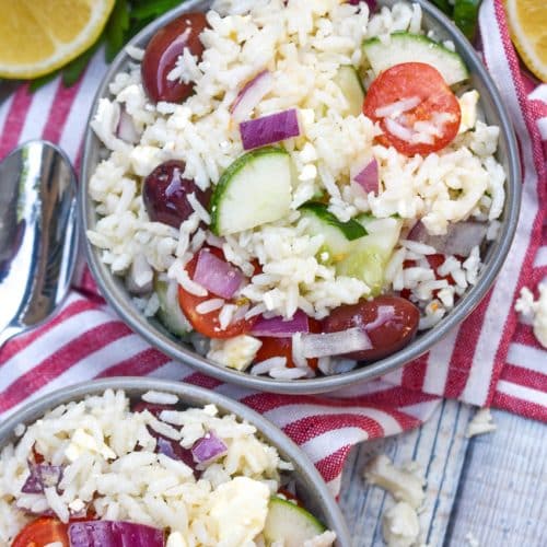 greek rice salad in two small gray bowls
