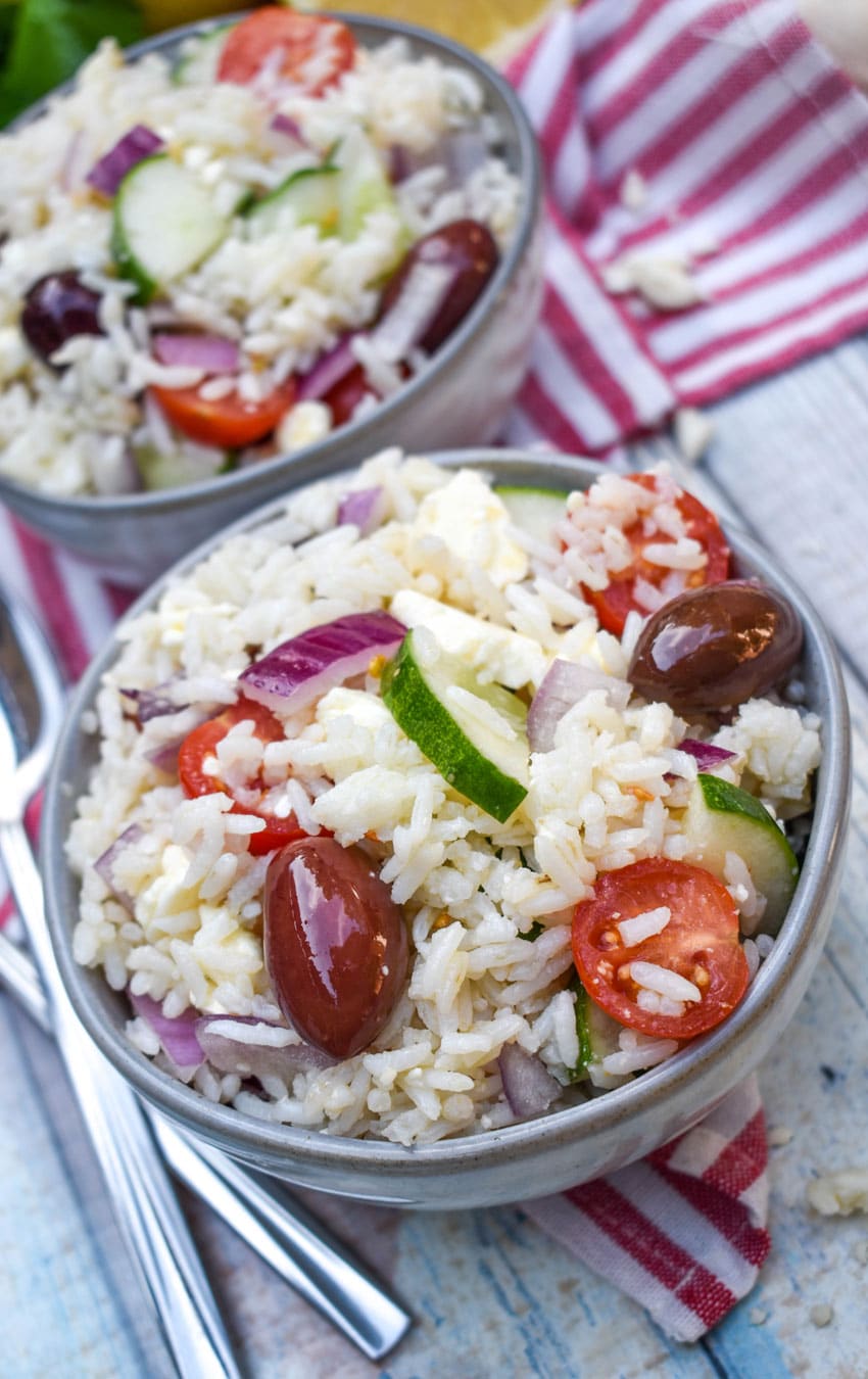 greek rice salad in two small gray bowls