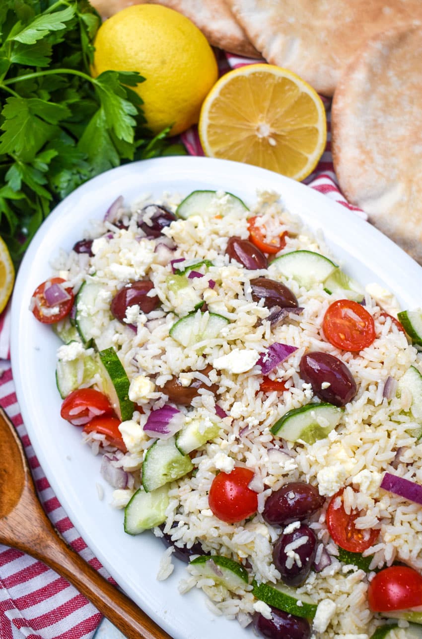 greek rice salad in a white serving bowl