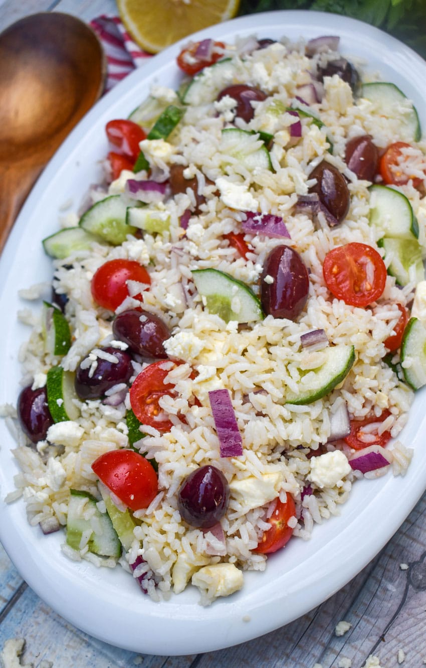 greek rice salad in a white serving bowl