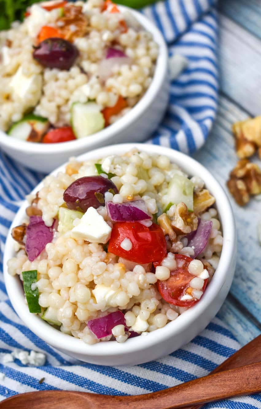 Mediterranean couscous salad in two small white bowls