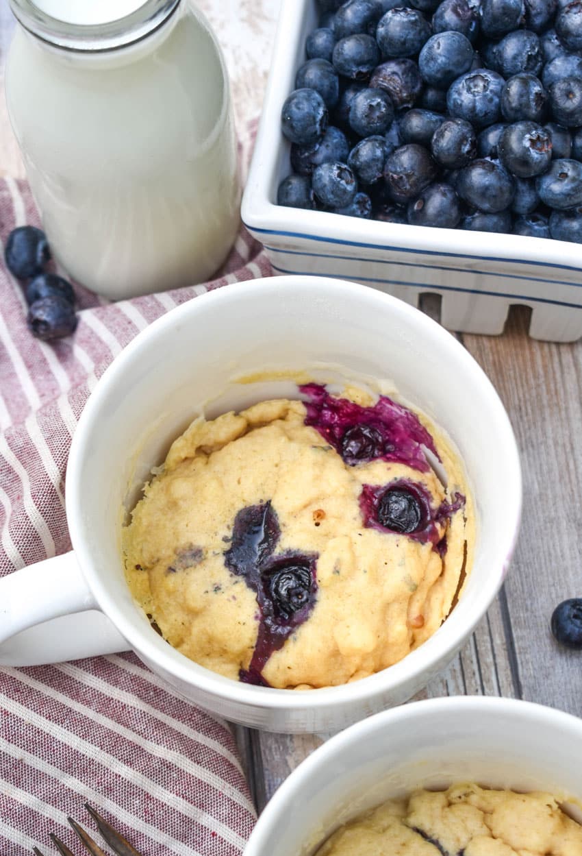 microwave blueberry muffin mug cakes in two white mugs