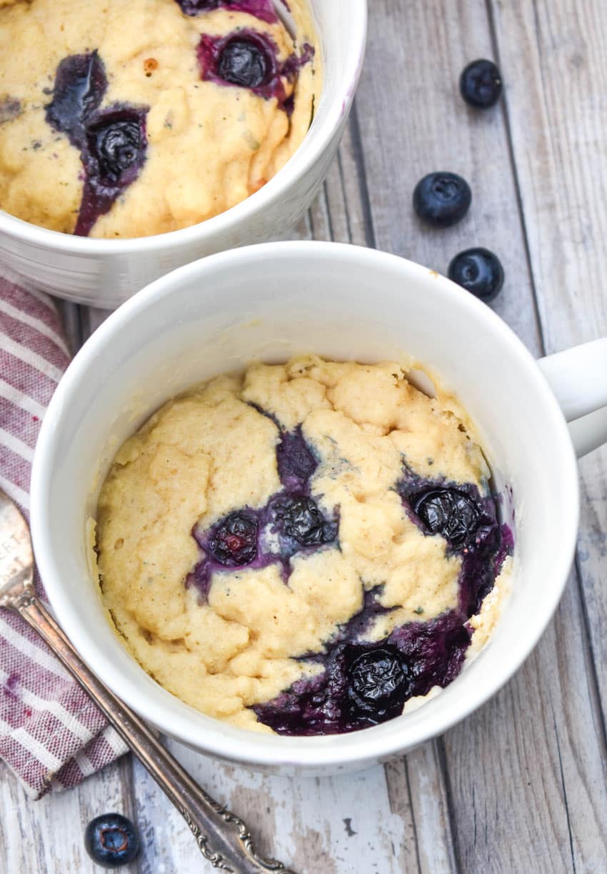 microwave blueberry muffin mug cakes in two white mugs