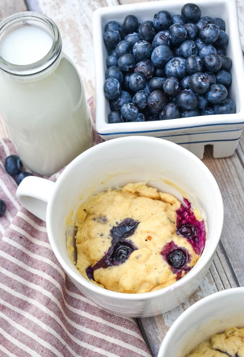 microwave blueberry muffin mug cakes in two white mugs