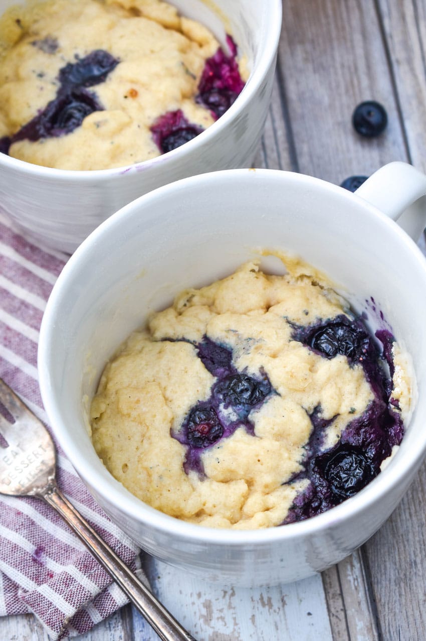 microwave blueberry muffin mug cakes in two white mugs