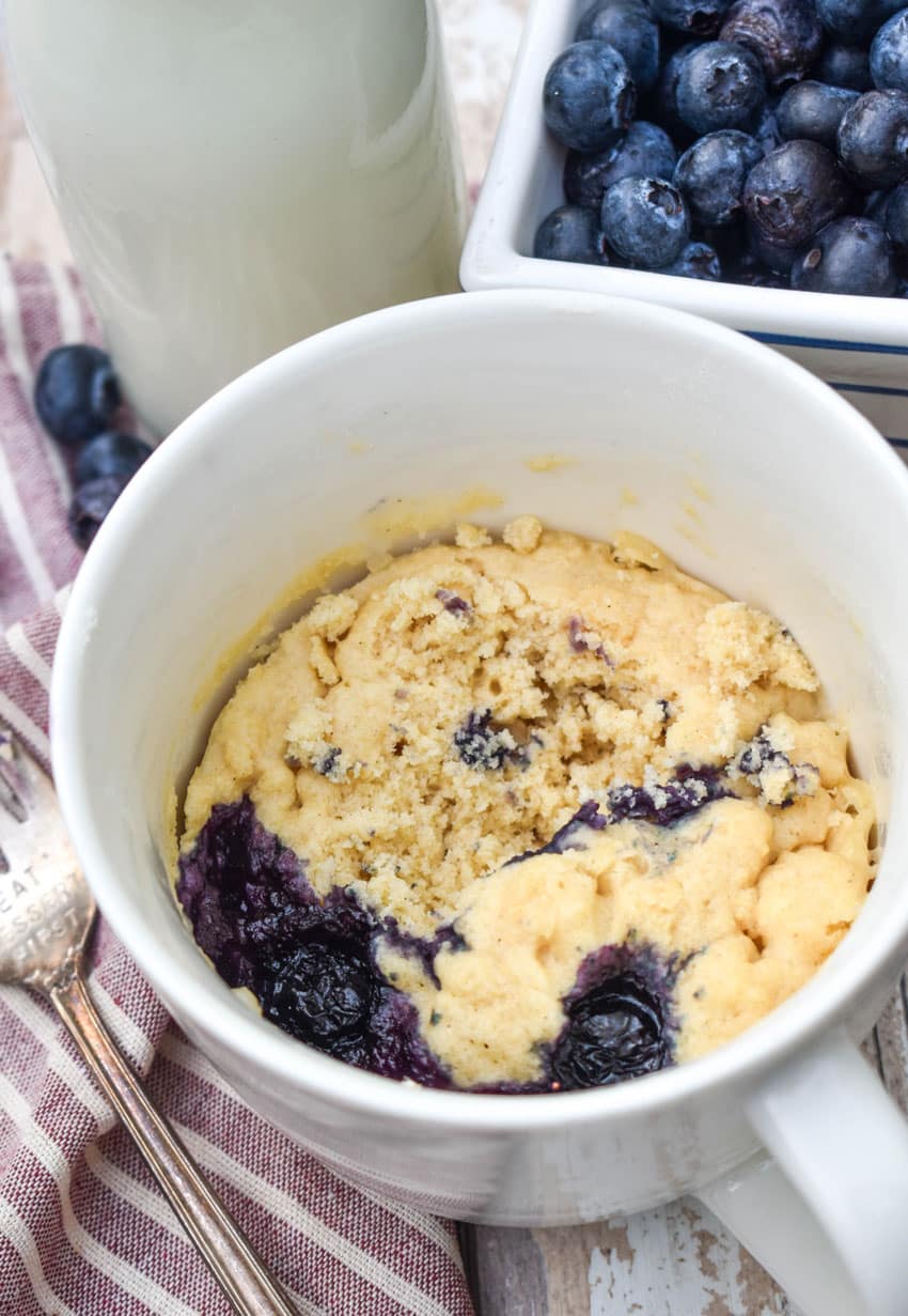 microwave blueberry muffin mug cakes in two white mugs