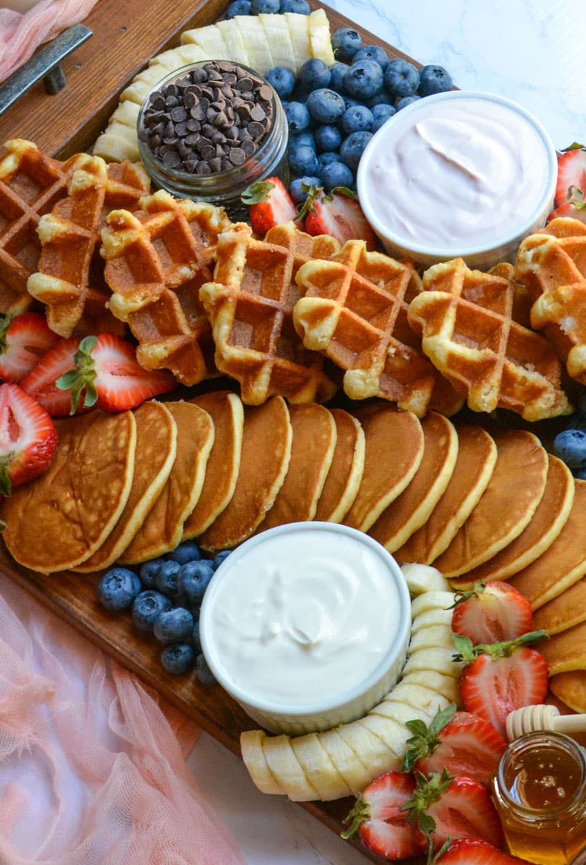 an overhead image of a pancake and waffle breakfast board spread