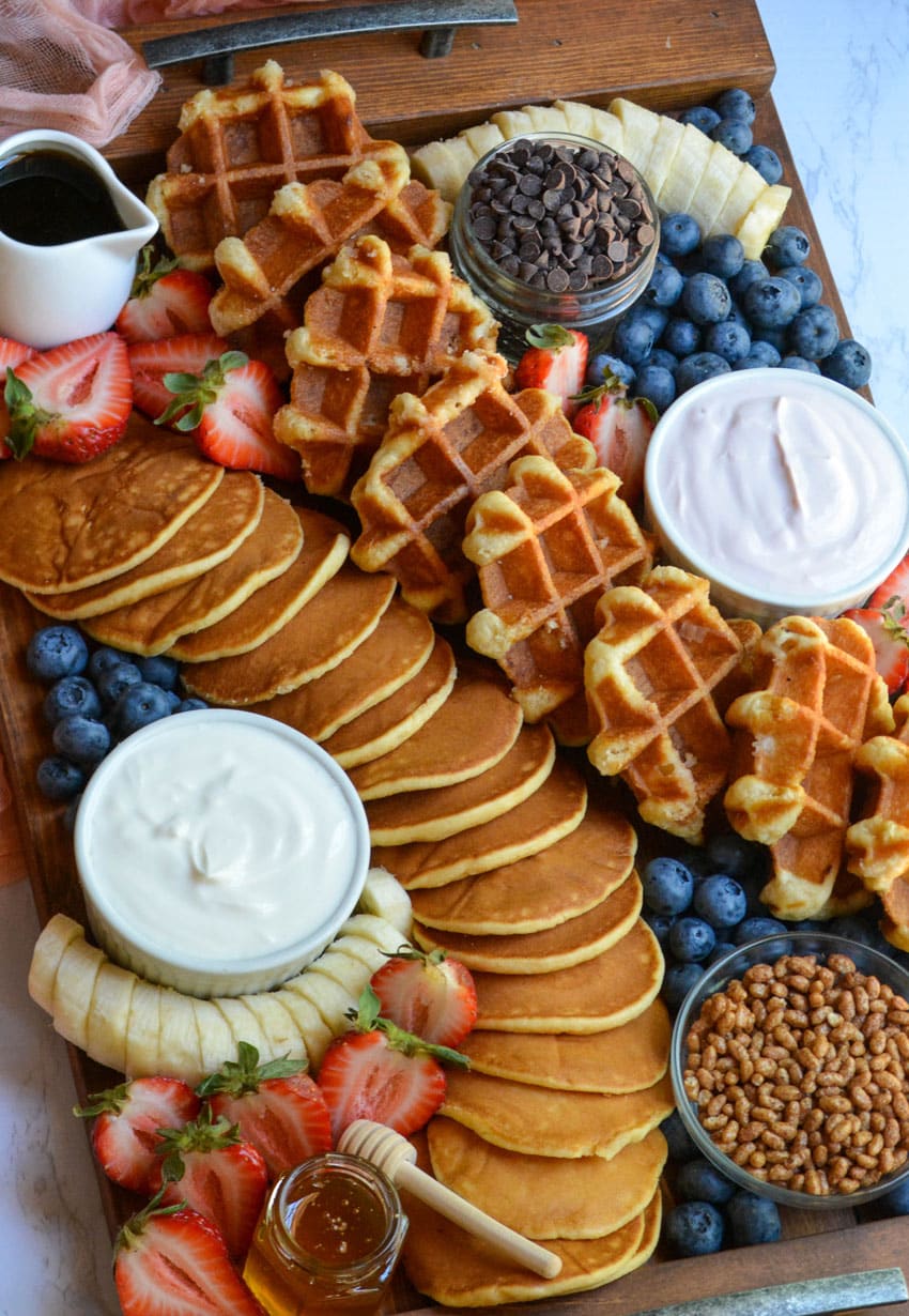 an overhead image of a pancake and waffle breakfast board spread