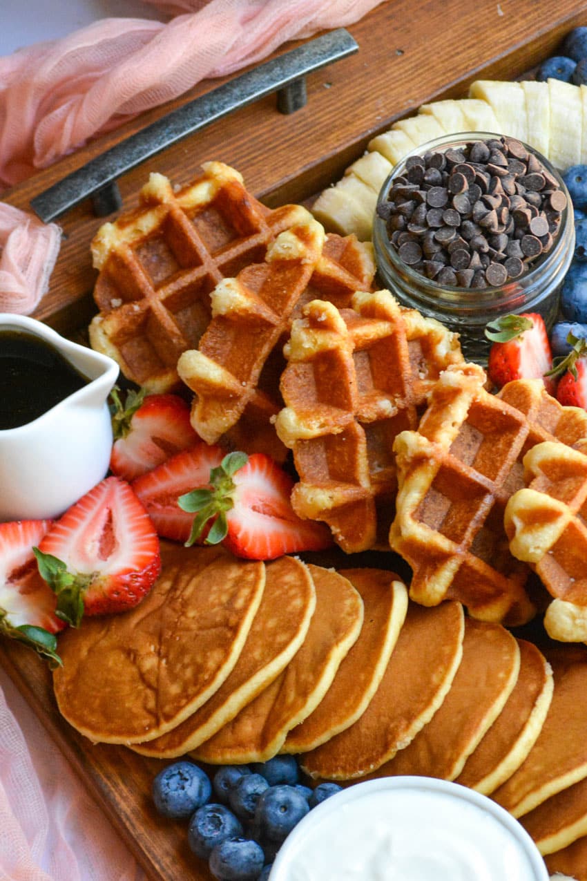 an overhead image of a pancake and waffle breakfast board spread