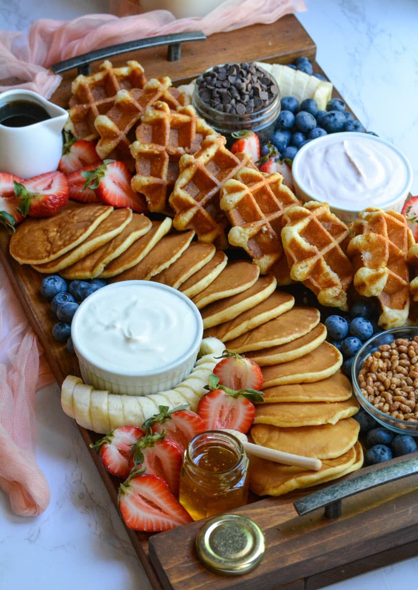 an overhead image of a pancake and waffle breakfast board spread