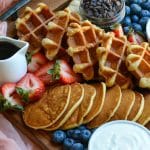 an overhead image of a pancake and waffle breakfast board spread