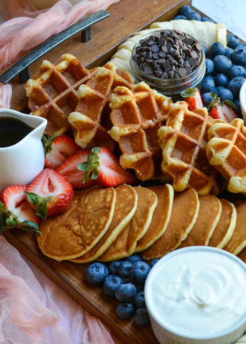 an overhead image of a pancake and waffle breakfast board spread
