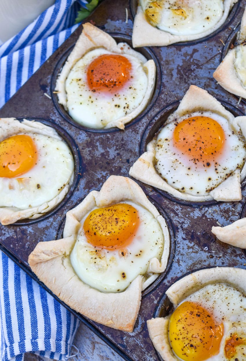 mini breakfast pie cups in the wells of a tin muffin pan