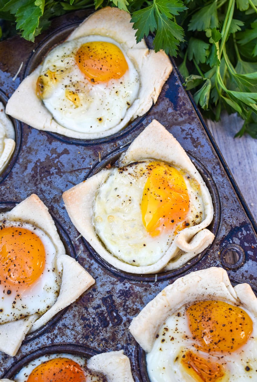 mini breakfast pie cups in the wells of a tin muffin pan