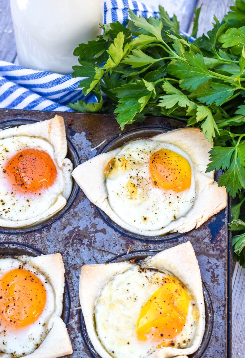 mini breakfast pie cups in the wells of a tin muffin pan