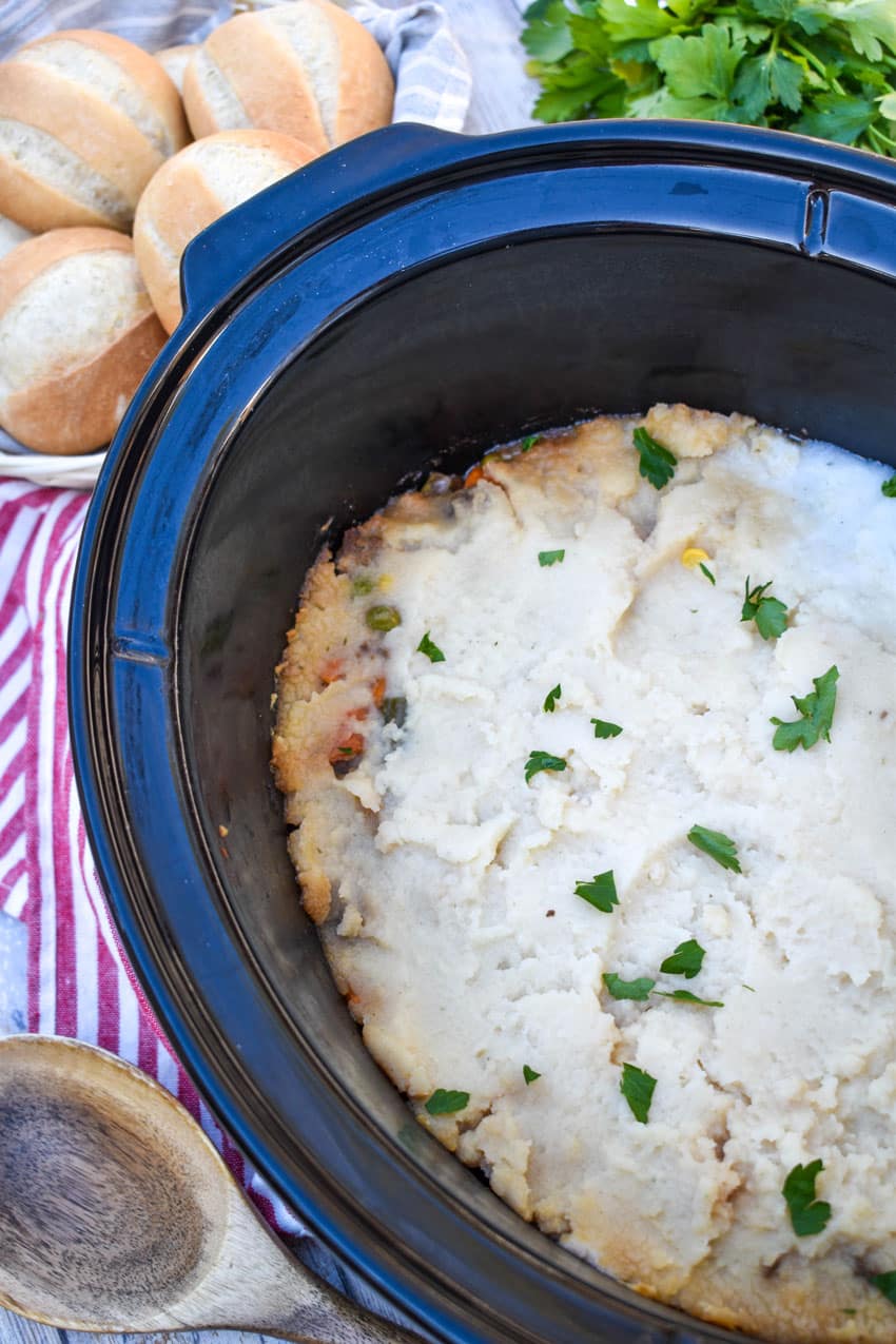 mashed potato topped shepherd's pie in the black bowl of a slow cooker