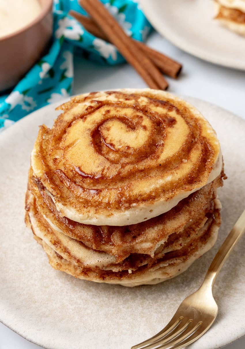 a stack of cinnamon swirl pancakes on a white plate