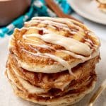 a stack of cinnamon roll pancakes on a white plate