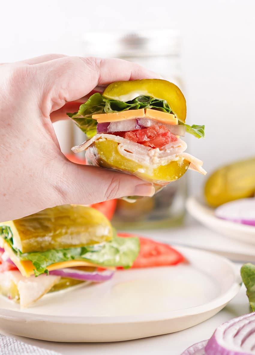 a hand holding up half of a picklewich sandwich