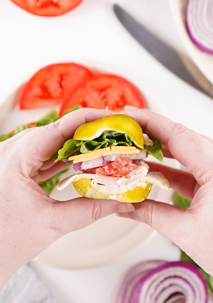 a hand holding up half of a picklewich sandwich
