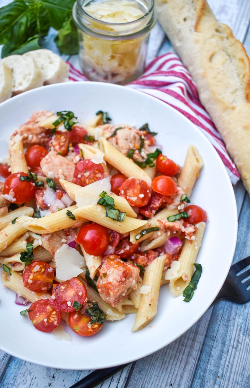bruschetta chicken and pasta on a white plate