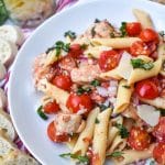 bruschetta chicken and pasta on a white plate