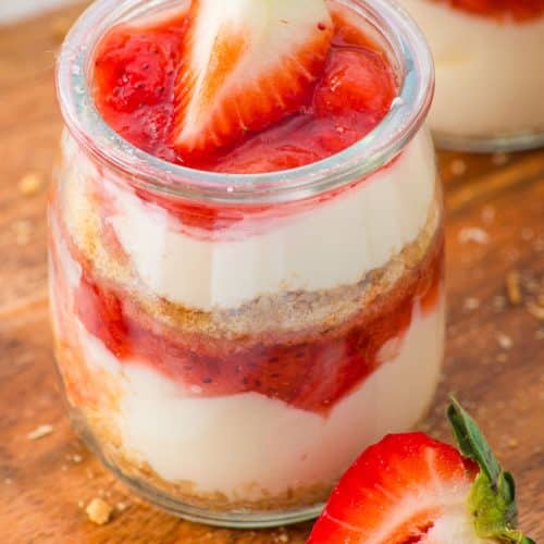 strawberry cheesecake cups on a wooden cutting board