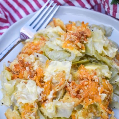 southern cabbage casserole on a white plate with a silver fork on the side