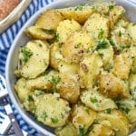 butter and parsley potatoes in a gray serving bowl