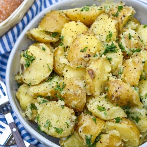 butter and parsley potatoes in a gray serving bowl