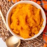 an overhead image showing homemade pumpkin puree in a small white bowl