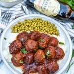 slow cooker guinness meatballs over mashed potatoes on a white plate