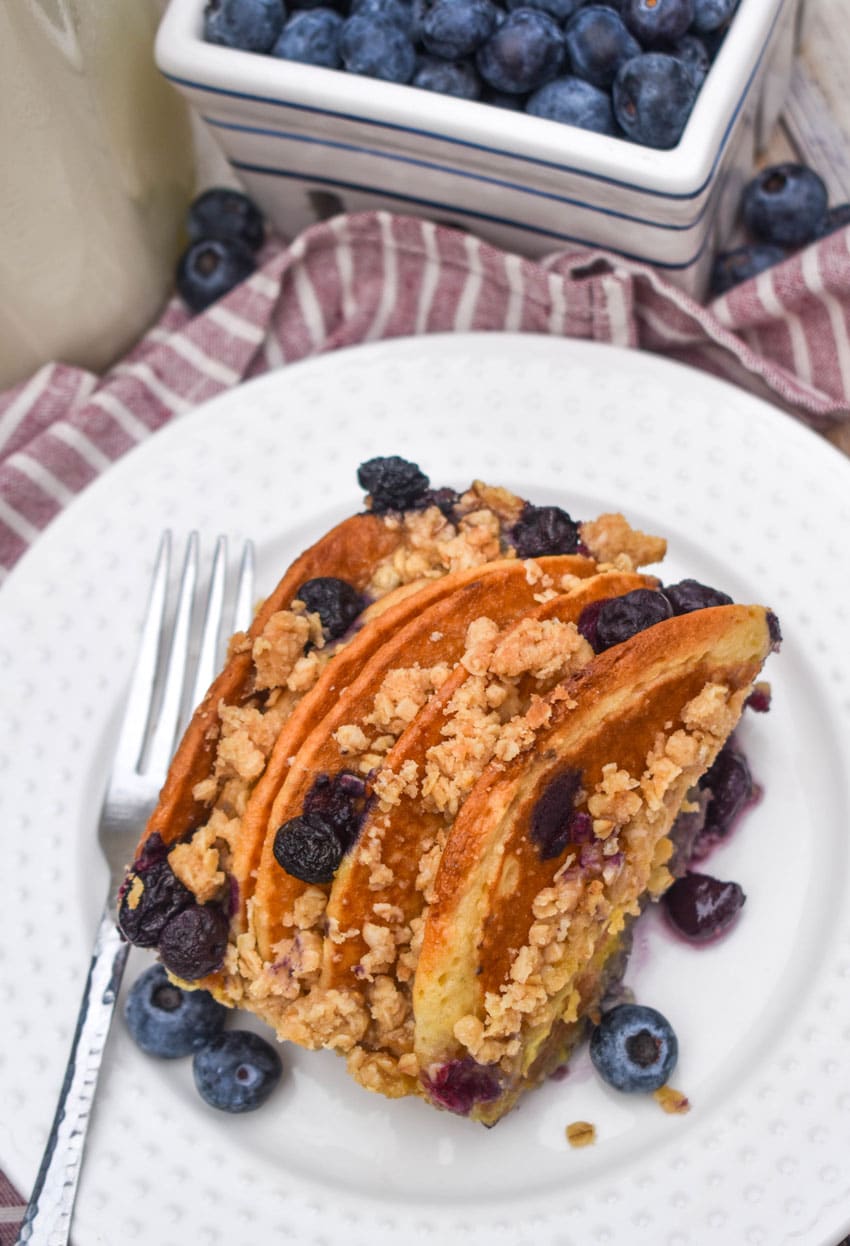 A SLICE OF BLUEBERRY PANCAKE CASSEROLE ON A SMALL WHITE PLATE