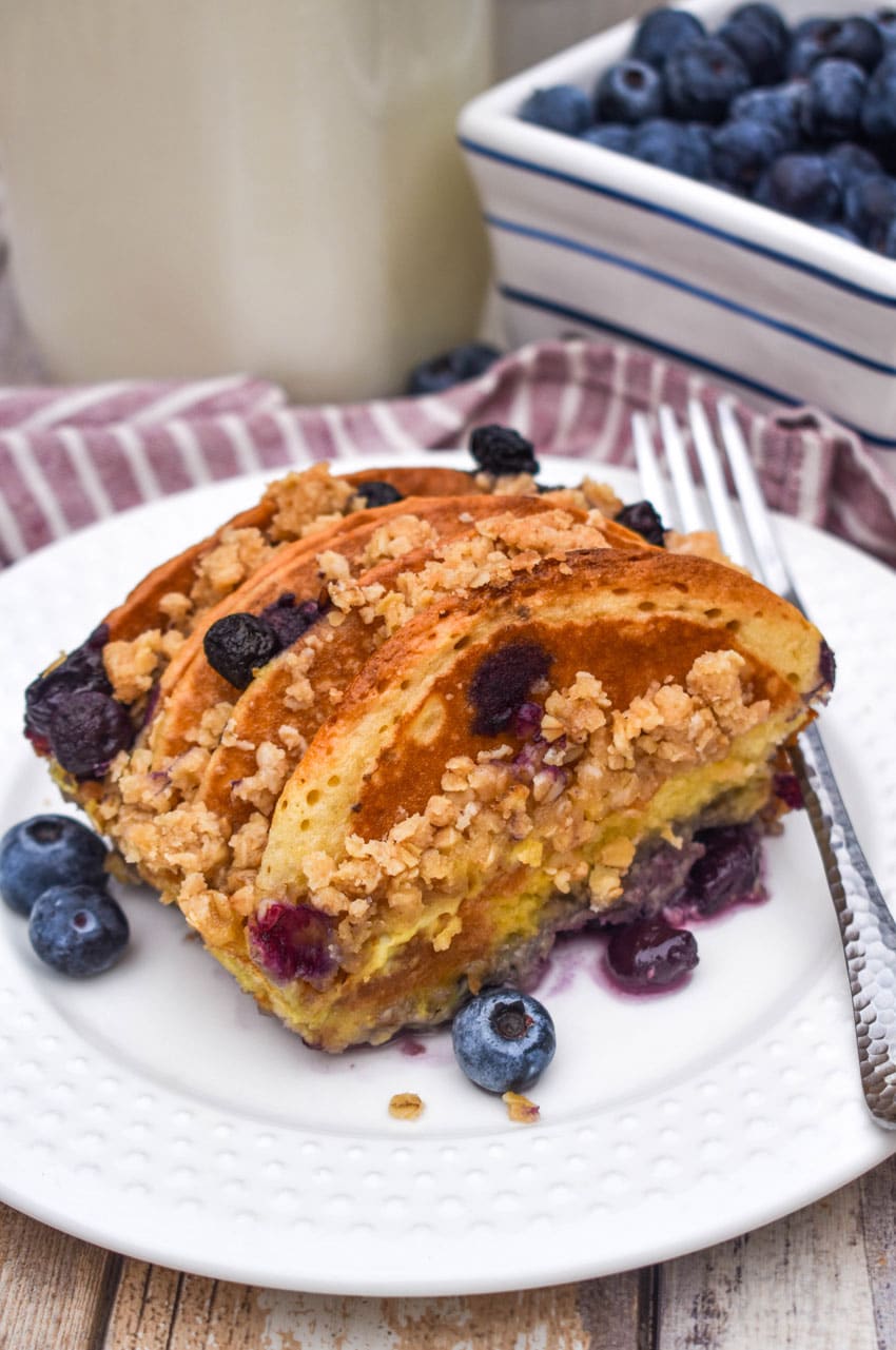 A SLICE OF BLUEBERRY PANCAKE CASSEROLE ON A SMALL WHITE PLATE