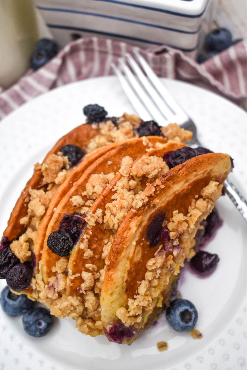 A SLICE OF BLUEBERRY PANCAKE CASSEROLE ON A SMALL WHITE PLATE