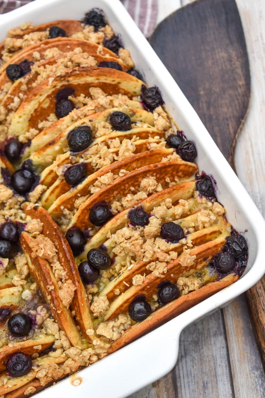 A BLUEBERRY PANCAKE CASSEROLE IN A WHITE SQUARE BAKING DISH