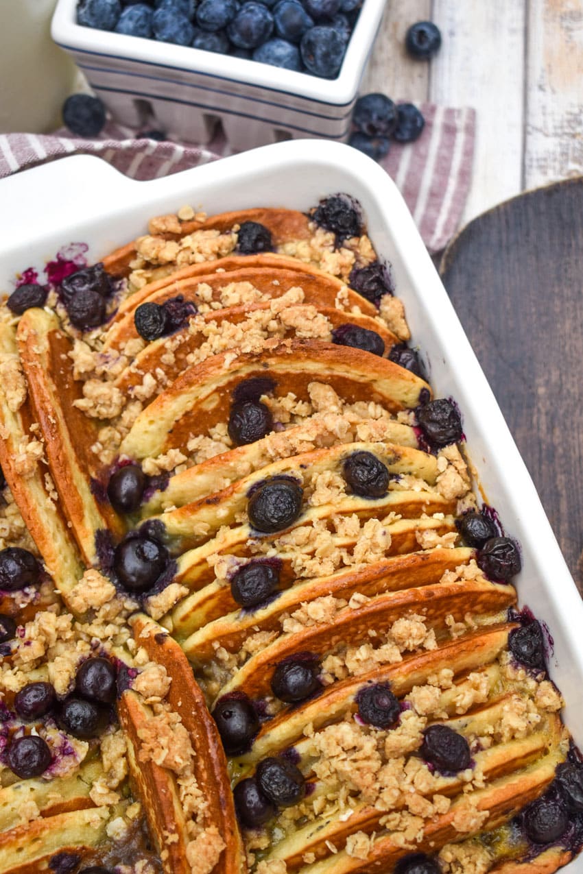 A BLUEBERRY PANCAKE CASSEROLE IN A WHITE SQUARE BAKING DISH