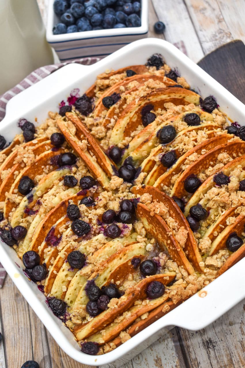 A BLUEBERRY PANCAKE CASSEROLE IN A WHITE SQUARE BAKING DISH