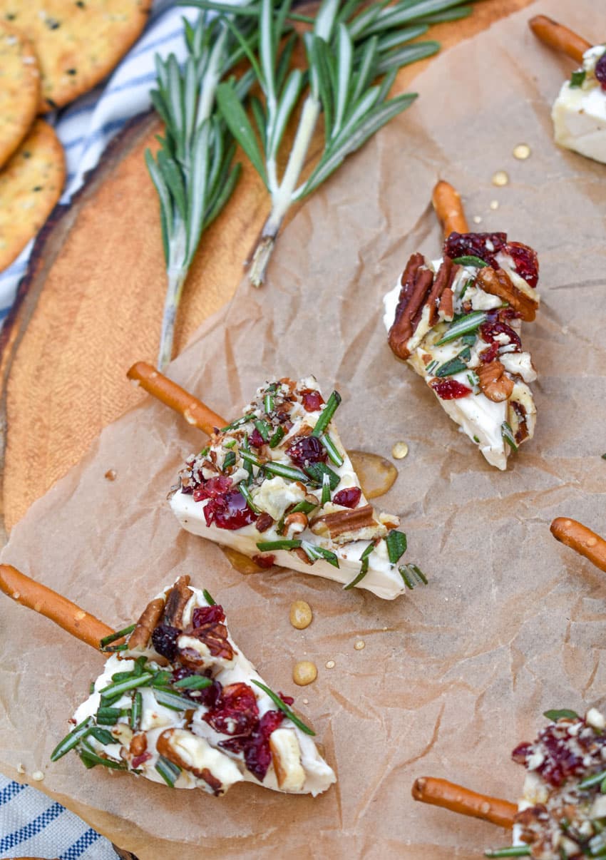 christmas cheese trees on a brown parchment paper covered wooden cutting board