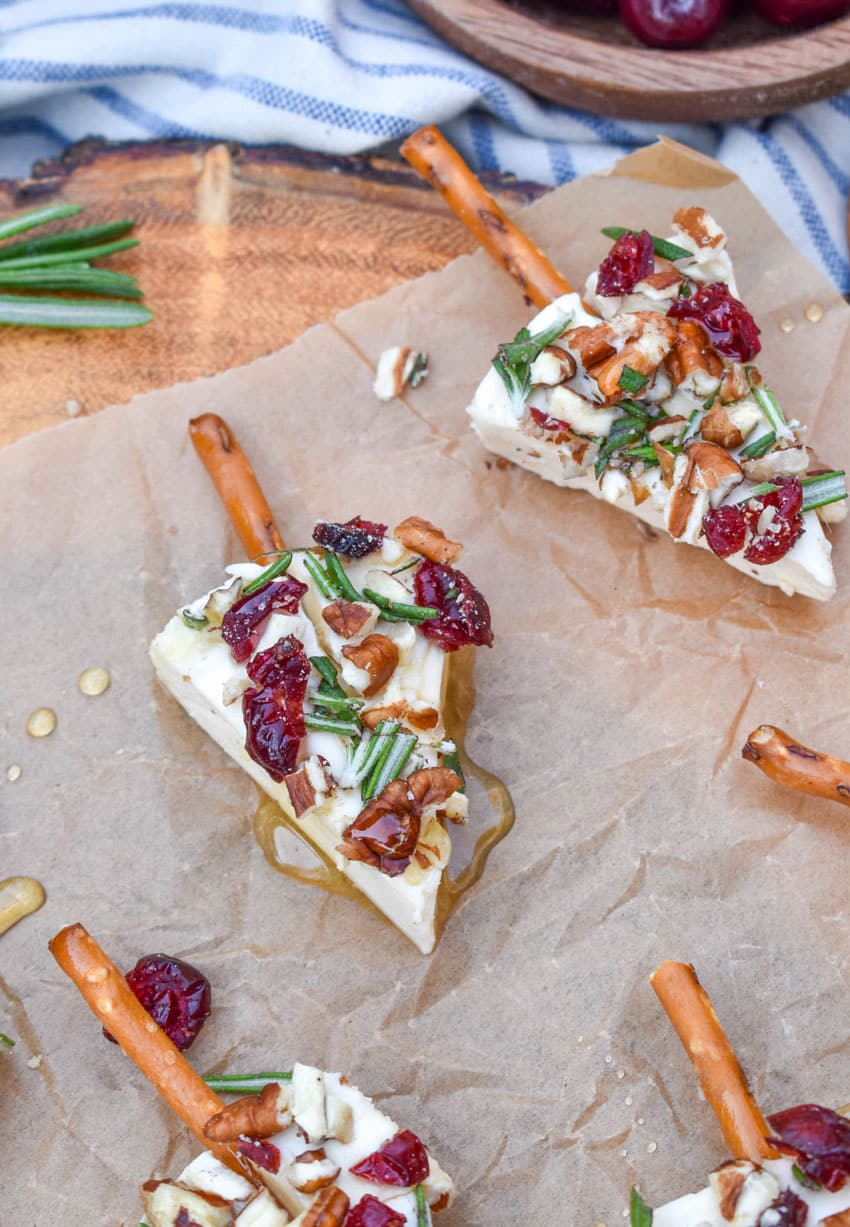 christmas cheese trees on a brown parchment paper covered wooden cutting board