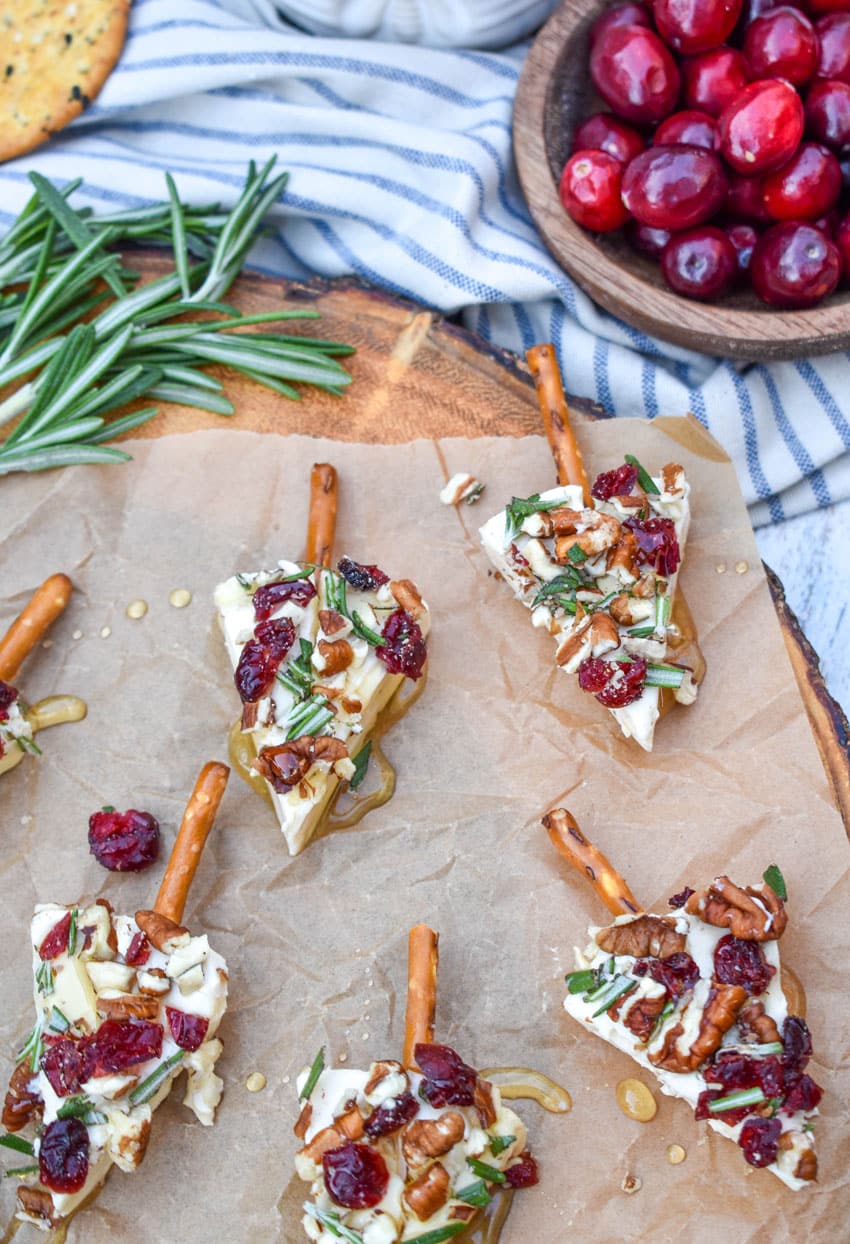 christmas cheese trees on a brown parchment paper covered wooden cutting board