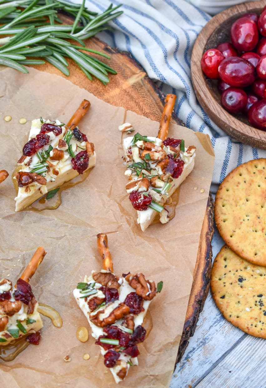 christmas cheese trees on a brown parchment paper covered wooden cutting board