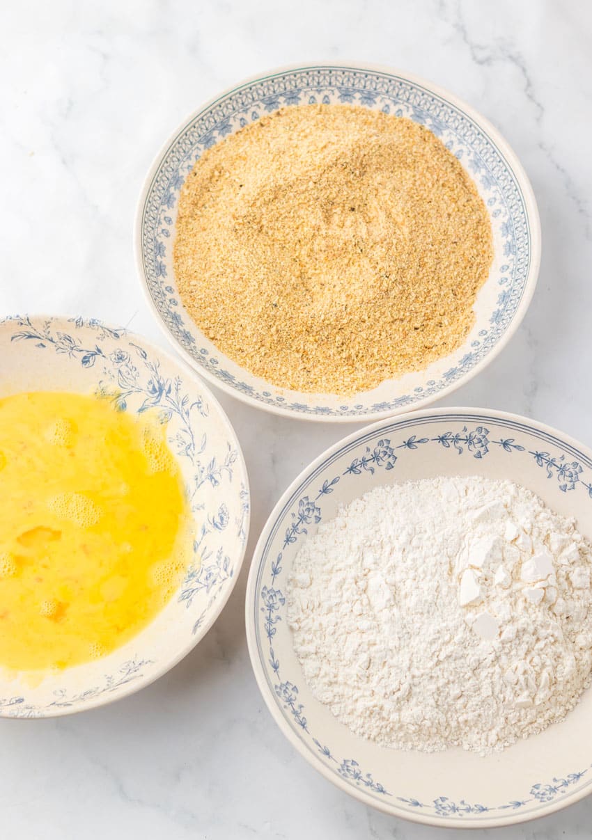breading ingredients in three shallow white bowls