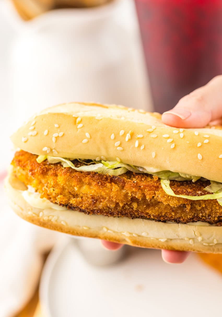 a hand holding up a copycat burger king original chicken sandwich