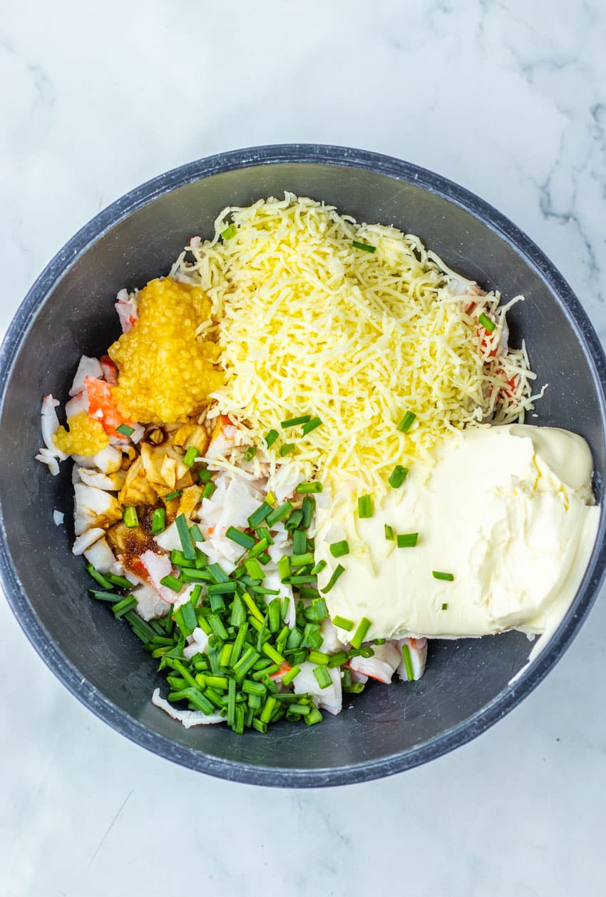 crab rangoon filling ingredients in a black mixing bowl